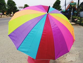 Close-up of multi colored umbrella on wet street