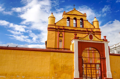 Low angle view of closed yellow iglesia de san nicolas entrance against sky