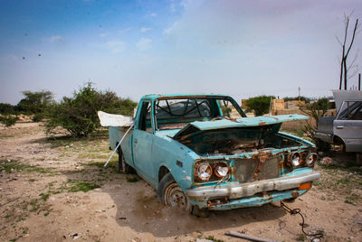 Abandoned car against sky