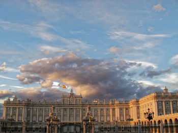 Low angle view of madrid royal palace against cloudy sky during sunset