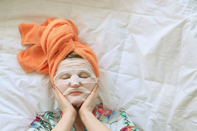 High angle portrait of woman lying on bed