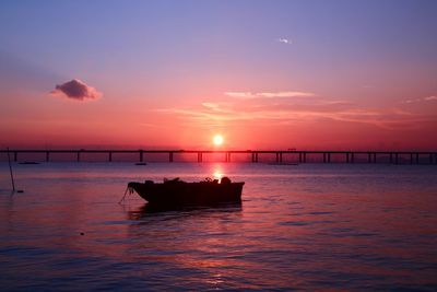 Silhouette boat in sea against sky during sunset