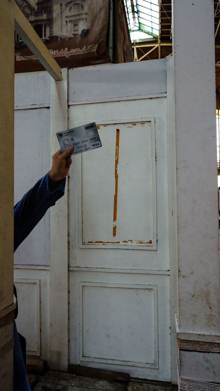 MAN HOLDING TEXT ON DOOR