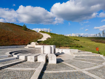 Built structure on landscape against cloudy sky