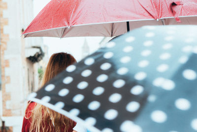 Woman holding wet umbrella in rain
