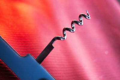 Close-up of corkscrew against illuminated background