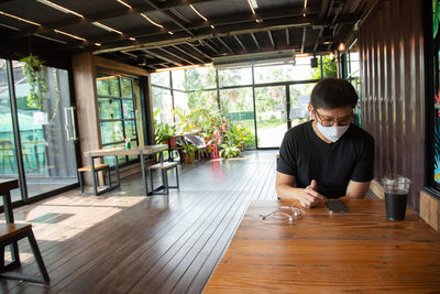 Full length of man sitting on table