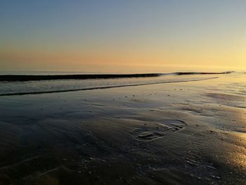 Scenic view of beach against sky during sunset