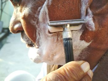 Close-up of man shaving beard