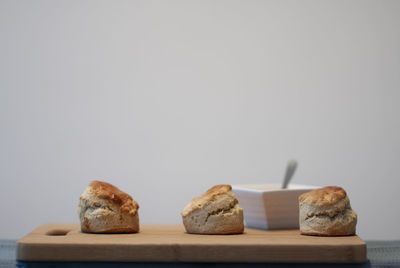 Traditional british scones with shot from the side on a wooden bread board.