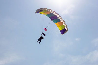 Low angle view of person paragliding against sky