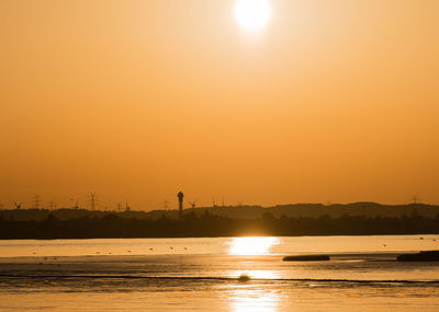 Scenic view of sea against orange sky