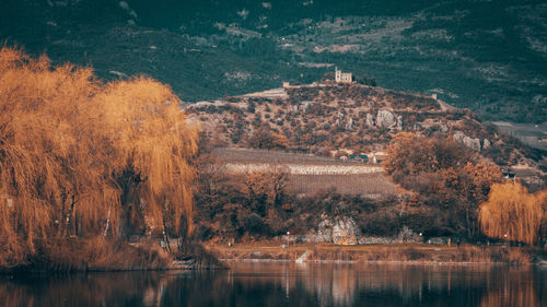 Scenic view of lake by buildings against mountain