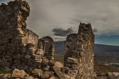 Old ruins of building against cloudy sky