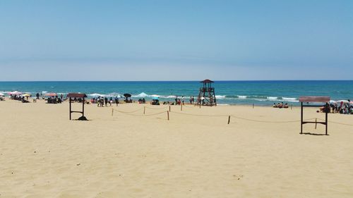 People at beach against blue sky