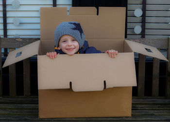 Portrait of playful boy on box