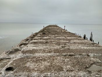 Pier against cloudy sky