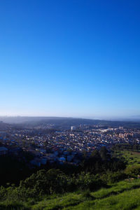 High angle view of cityscape against blue sky