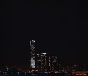 Illuminated buildings against clear sky at night