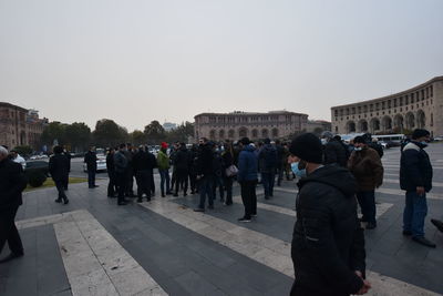 Group of people in city against clear sky