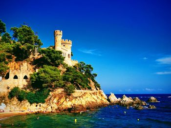 Building by sea against blue sky