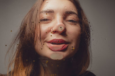 Close-up portrait of woman seen through wet glass with star shape decoration