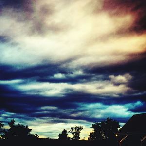 Silhouette of trees against cloudy sky