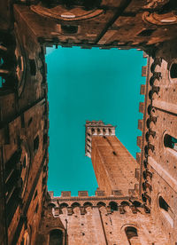 Directly below shot of buildings against blue sky