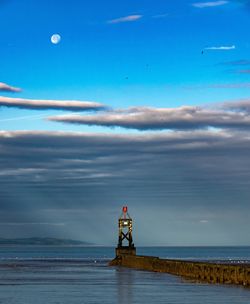 Scenic view of lighthouse by sea against sky