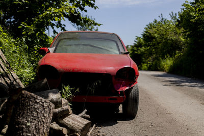 Abandoned car on road against sky