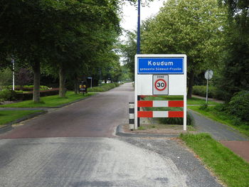 Road sign by trees