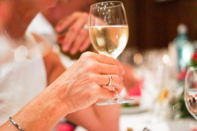 Close-up of hand holding glass of wine in restaurant