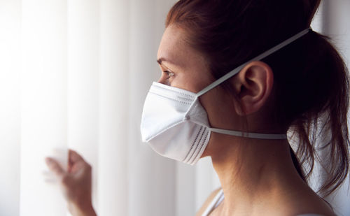Close-up portrait of young woman against wall