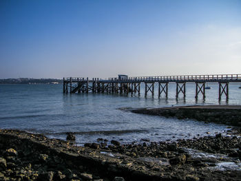 Pier over sea against clear sky