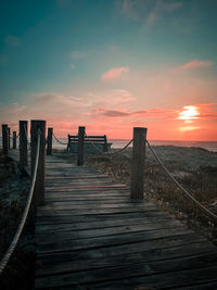 Pier over sea against sky during sunset