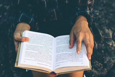 Midsection of person holding book