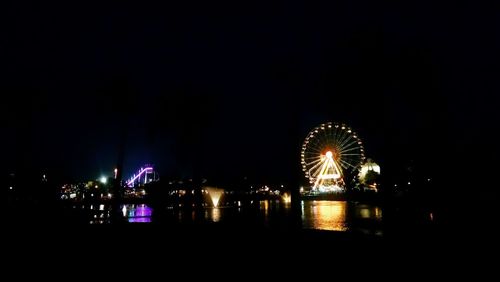 Illuminated ferris wheel at night