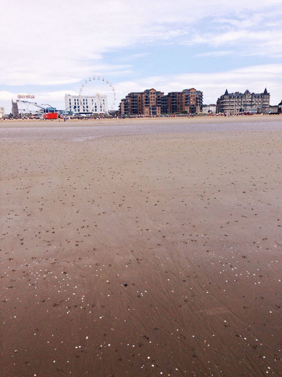 building exterior, architecture, built structure, beach, sky, sand, water, sea, shore, cloud - sky, city, day, wet, outdoors, incidental people, cloud, building, cloudy, residential structure, no people