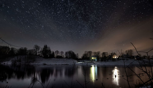 Scenic view of lake against sky at night