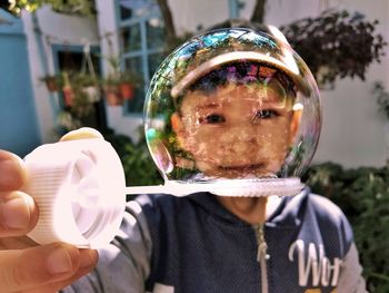 Close-up portrait of boy holding bubbles