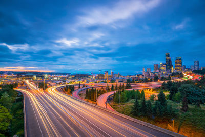 High angle view of light trails on highway against sky at night