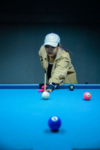 Midsection of woman playing pool