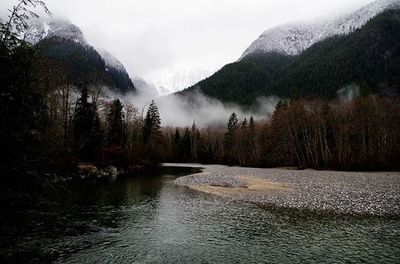 Scenic view of river and mountains against sky