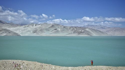 Scenic view of sea and mountains against sky