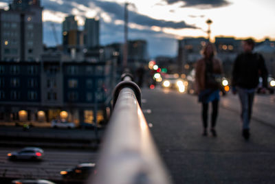 People in illuminated city against sky