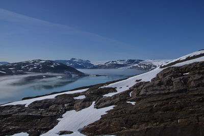 Scenic view of snowcapped mountains against clear blue sky