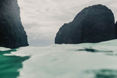 Rock formations by sea against sky