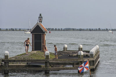 People on river against clear sky