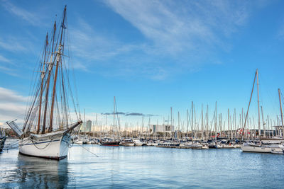 Sailboats moored in sea against blue sky