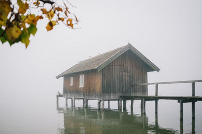 House by lake against clear sky